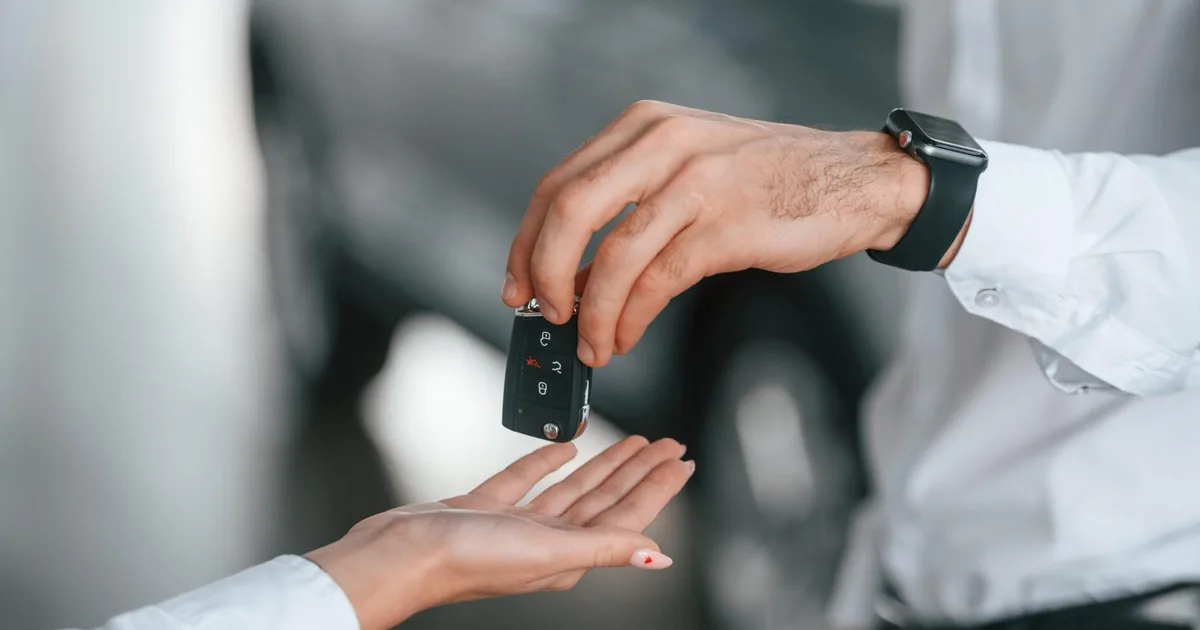 Rental agent handing car keys to a customer for a car rental in Miami, Florida